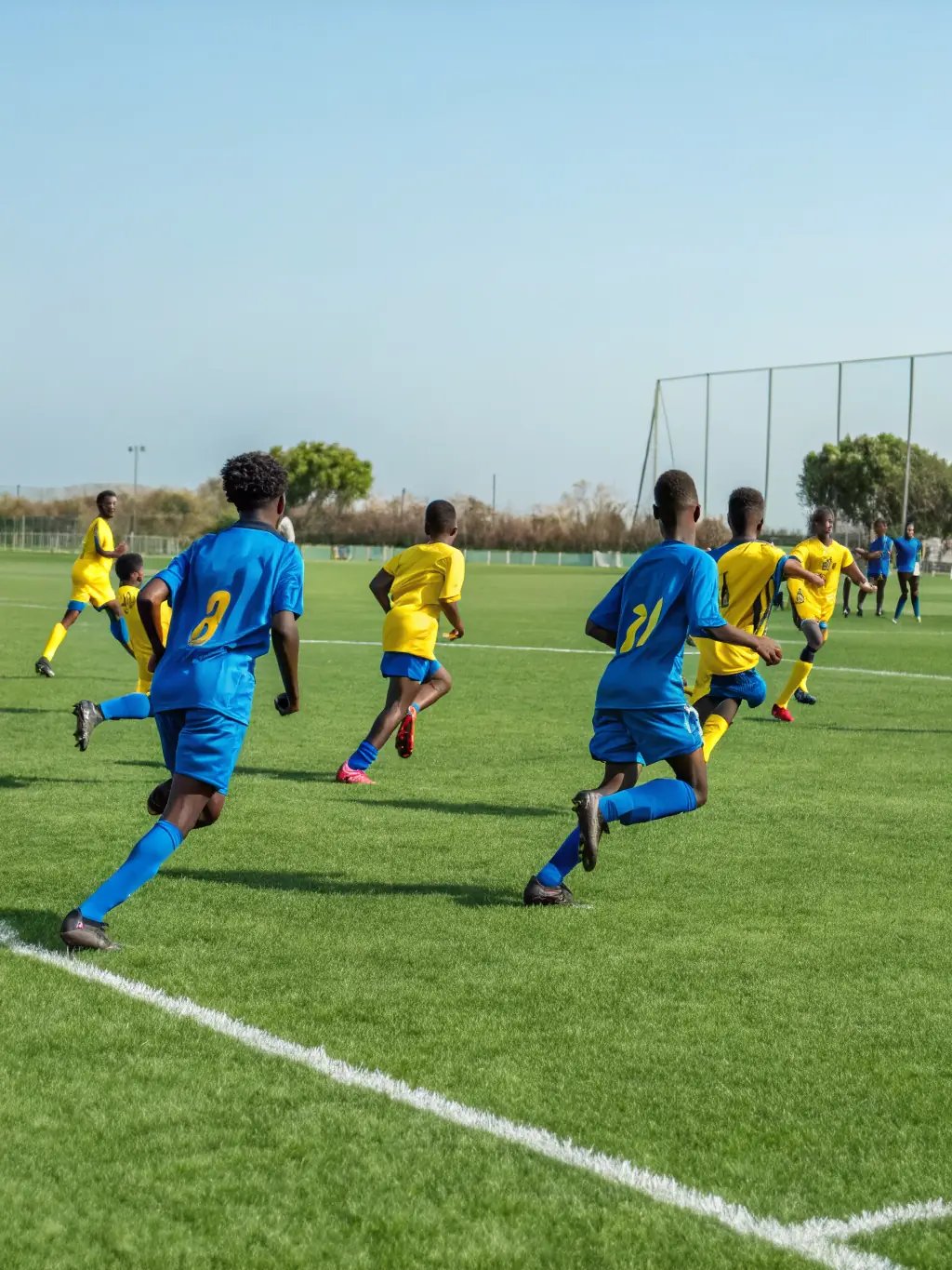 A group of students practicing soccer drills on a field, highlighting agility and ball control.